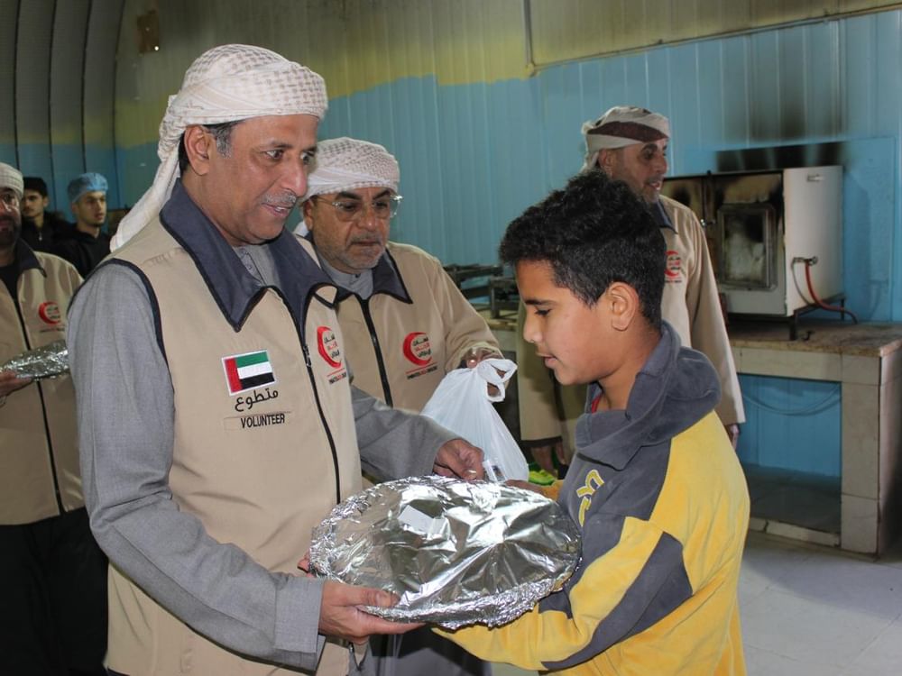 Moradores de Mrajeeb Al Fhood recebem refeições de Ramadã no Dia Humanitário Zayed